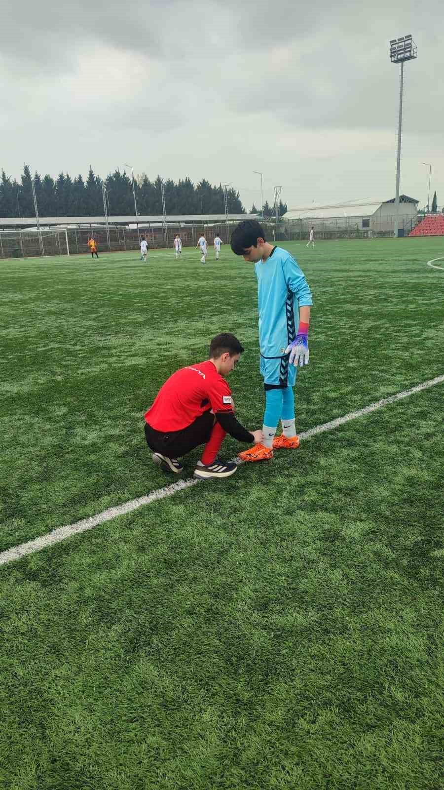 Hakem futbolcunun kramponlarını bağladı
